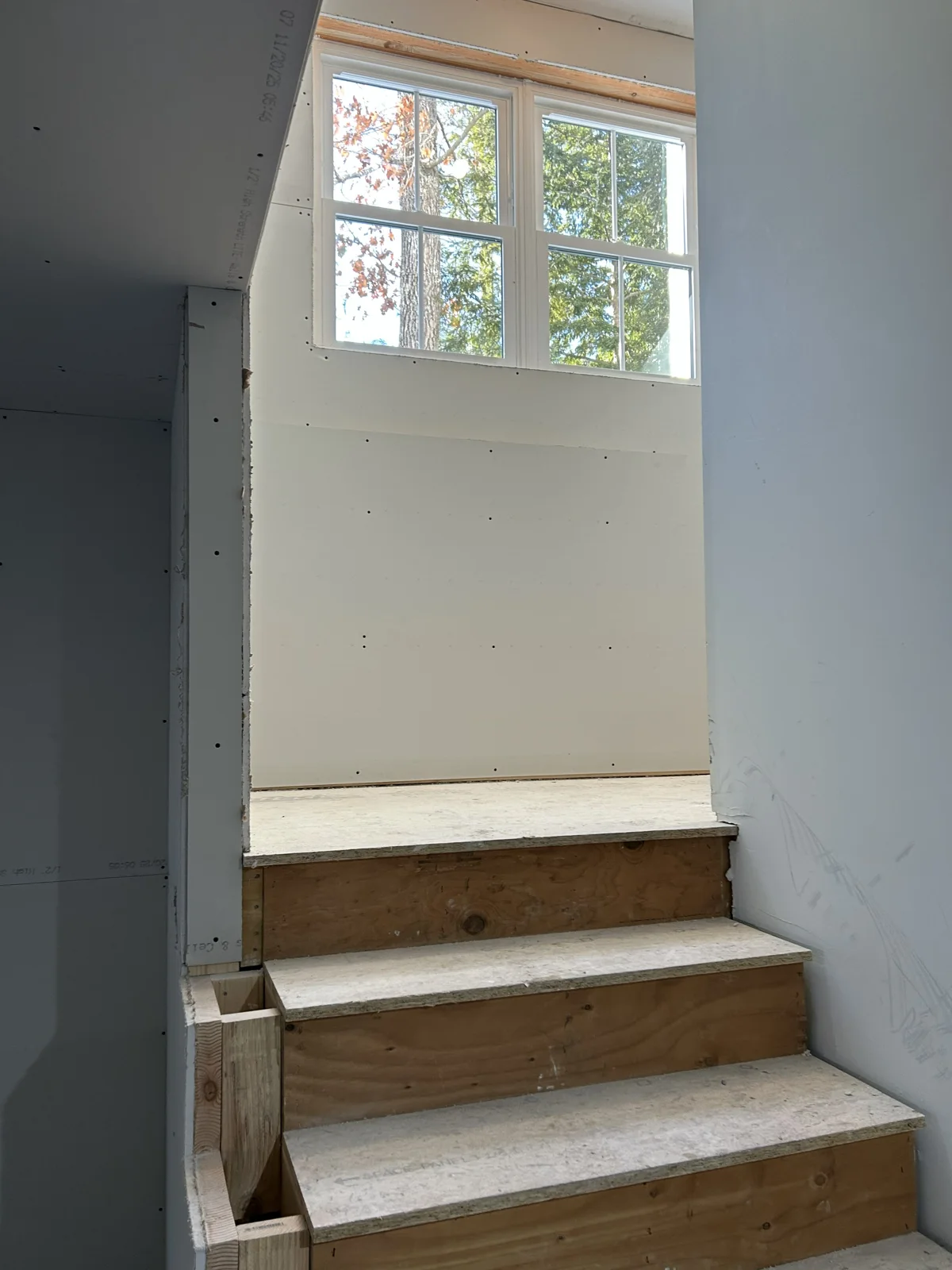 Sheetrock hung under the stairs headed down to the basement.